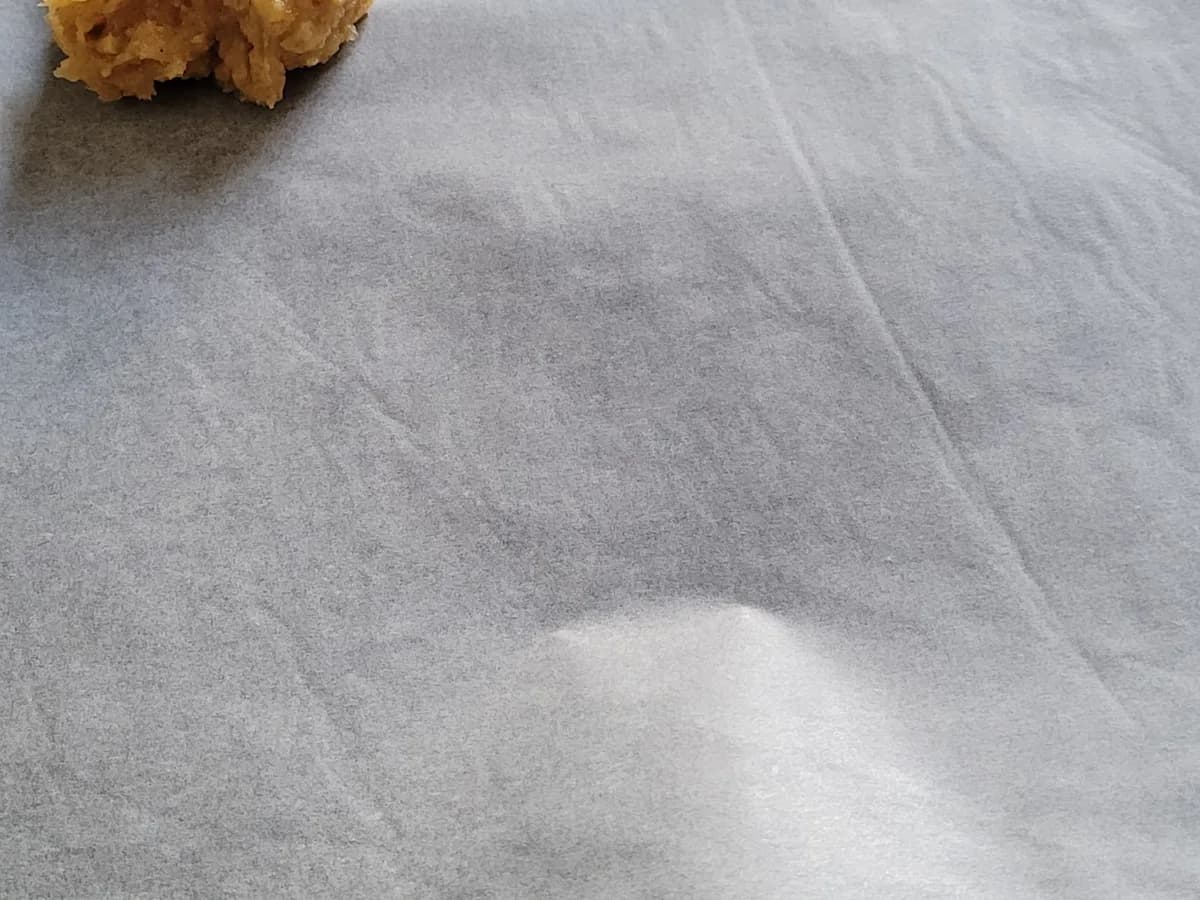 A scoop of peanut butter cookie dough on a parchment-lined baking tray